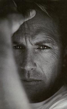 black and white photograph of a man holding his hand up to his face