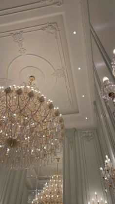 a chandelier hanging from the ceiling in a room with white walls and ceilings