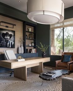 a living room filled with furniture and a painting on the wall above a coffee table