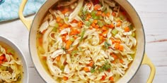 two bowls filled with chicken noodle soup on top of a table