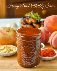 a jar filled with bbq sauce sitting on top of a wooden table next to other ingredients