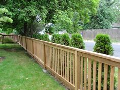 a wooden fence in front of some trees