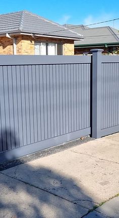 a grey fence in front of a house