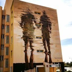 a large painting on the side of a building with trees painted on it's sides