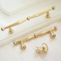 two gold handles and knobs on a white bathtub