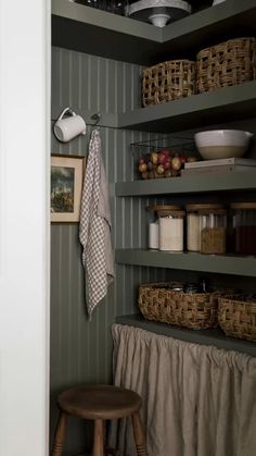 a kitchen with green walls and shelves filled with food