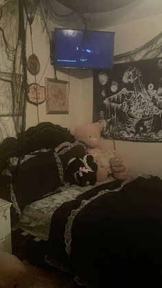 a bedroom with a bed, tv and stuffed animals on the wall in it's corner