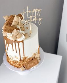 a white cake with chocolate and marshmallows on top that says happy birthday