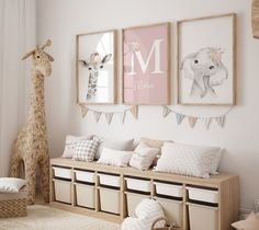 a baby's room with pink and white decor, giraffes hanging on the wall