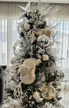 a white christmas tree decorated with ornaments and teddy bears