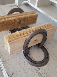 a brush sits on top of a piece of wood next to a pair of scissors