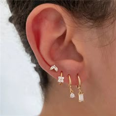 a woman's ear with three small white stones on it