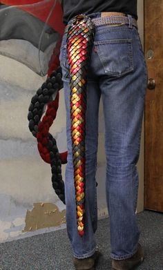 a person with a colorful braid on their back and some bracelets in his hand