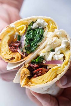 two burritos filled with meat, cheese and spinach on top of each other