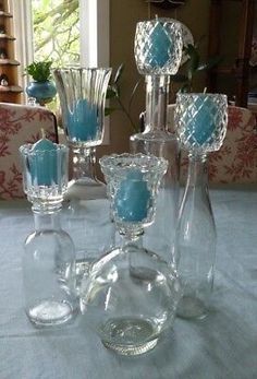 there are many glass vases on the table