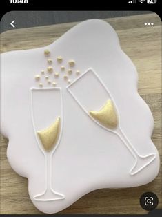 two champagne flutes on a white plate with gold accents