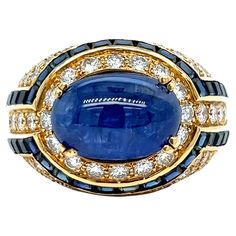 Boucheron sapphire diamond gold ring Cabochon sapphire of approximately 9.85 carats, square-cut sapphires of approximately 2 carats, round-cut diamonds of approximately 4 carats, 18 karat yellow gold; marked Boucheron, 750 Size: 7.5 US Total weight: 22.4 grams Luxury Sapphire Ring With Cabochon, 1stdibs Jewelry, Diamond Gold Ring, Rose Gold Diamond Ring, Jewels Rings, Morganite Ring, Ancient Jewelry, Sapphire Bracelet, Diamond Gold