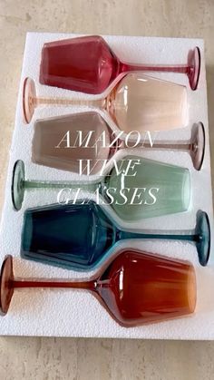 four different colored glass vases sitting on top of a white towel with the words amazon wine glasses