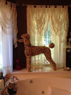 a dog made out of flowers sitting on top of a bathtub next to a window