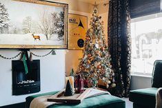 a living room with a christmas tree in the corner and a painting on the wall