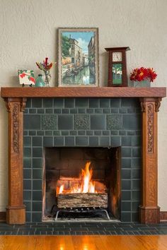 a fireplace with a fire in it and some pictures on the top shelf above it