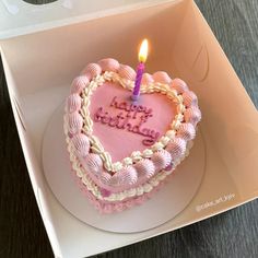 a heart shaped birthday cake with a lit candle