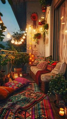 a balcony with lots of plants and lights on the windows sill, rugs and pillows