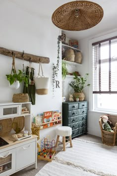 a living room filled with lots of furniture and plants on the wall next to a window