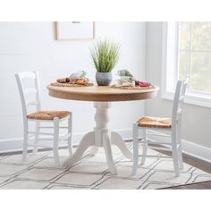 a white table with two chairs and a potted plant on top of the table