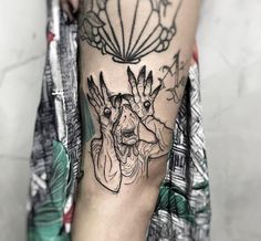 a woman's leg with tattoos on it and an image of two hands in the middle