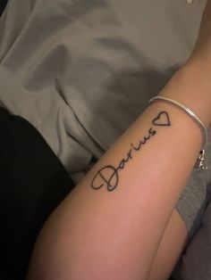 a person with a tattoo on their arm that reads, daintye and has the word daintye written in cursive font