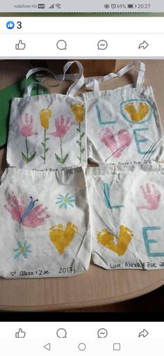 three bags with flowers on them sitting on a table next to a green marker board