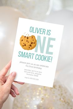 a person holding up a card that says,'silver is one smart cookie please join us we celebrate his first birthday '