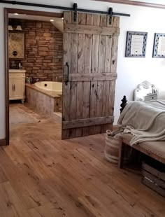 an open door leading to a bedroom with a bed and bathtub in the background