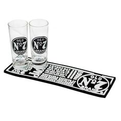 two shot glasses sitting on top of a black and white mat with the words no to alcohol