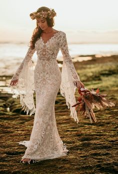 a woman in a white dress standing on the beach