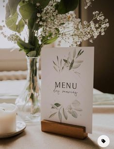 a table with a card and some flowers in a glass vase on top of it