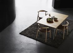 a wooden table with two bowls of food on top of it in front of a window