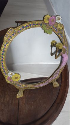 an ornate mirror on top of a wooden table