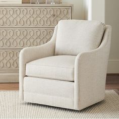 a white chair sitting on top of a rug next to a dresser