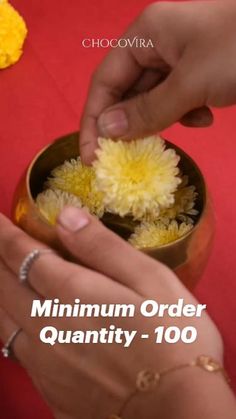 a person placing flowers in a bowl on top of a red tablecloth with the words,'minim order quantity - 100 '