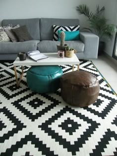 a living room with a couch, coffee table and ottoman in front of a large window