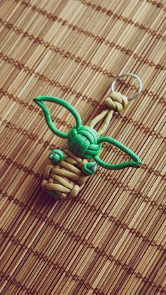 a green keychain sitting on top of a bamboo mat