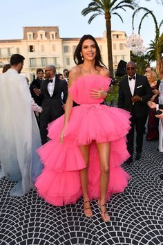 a woman in a pink dress posing for the camera