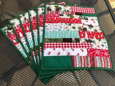 four christmas placemats sitting on top of a metal table next to each other