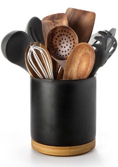 a black cup filled with wooden utensils and spatulas