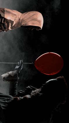 a man holding a red frisbee on top of a black and white photo