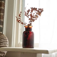 a red vase with some flowers in it