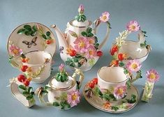 a tea set with flowers and butterflies on it