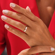 a woman's hand with white manicured nails and a ring on her finger